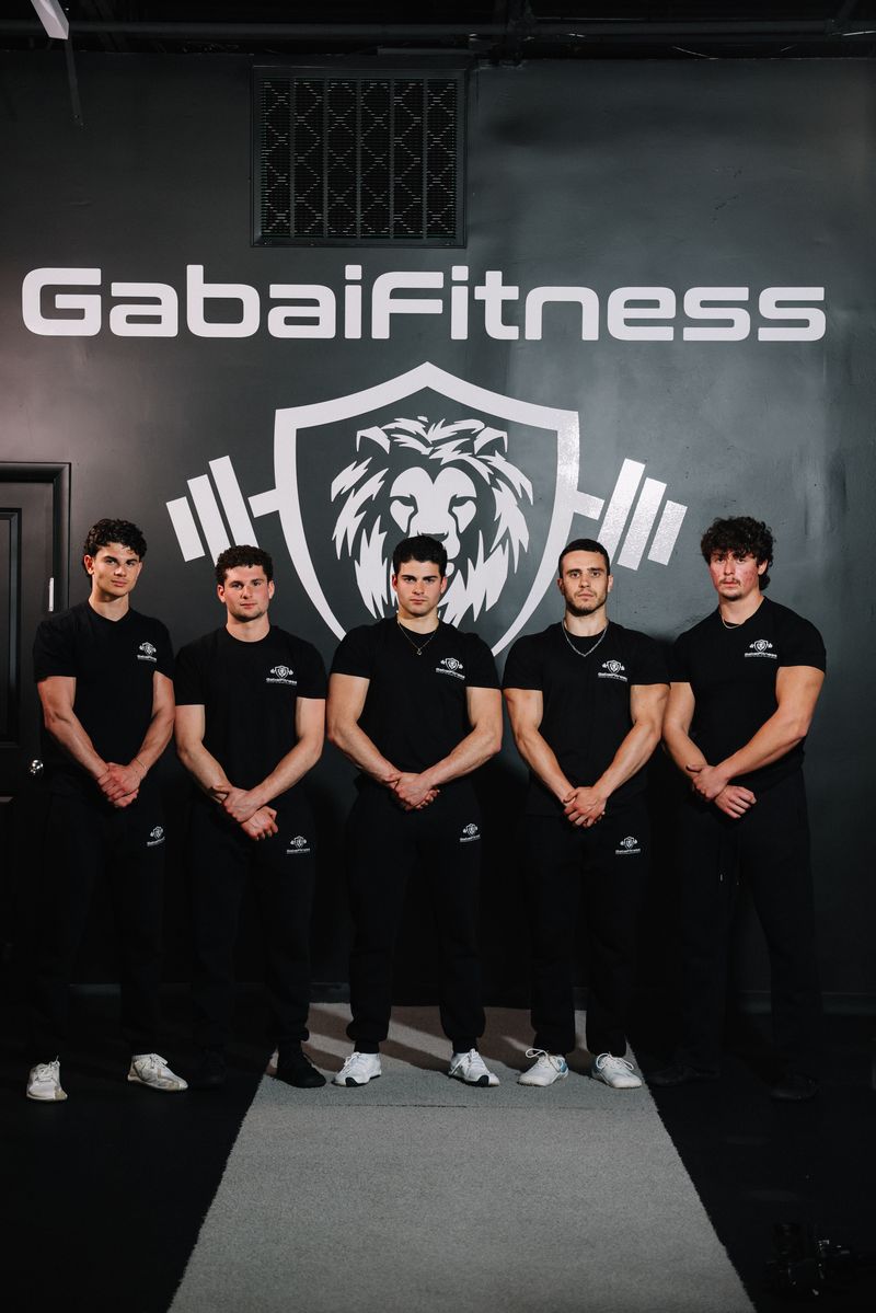 The Gabai Fitness coaching team in front of the GabaiFitness lion crest